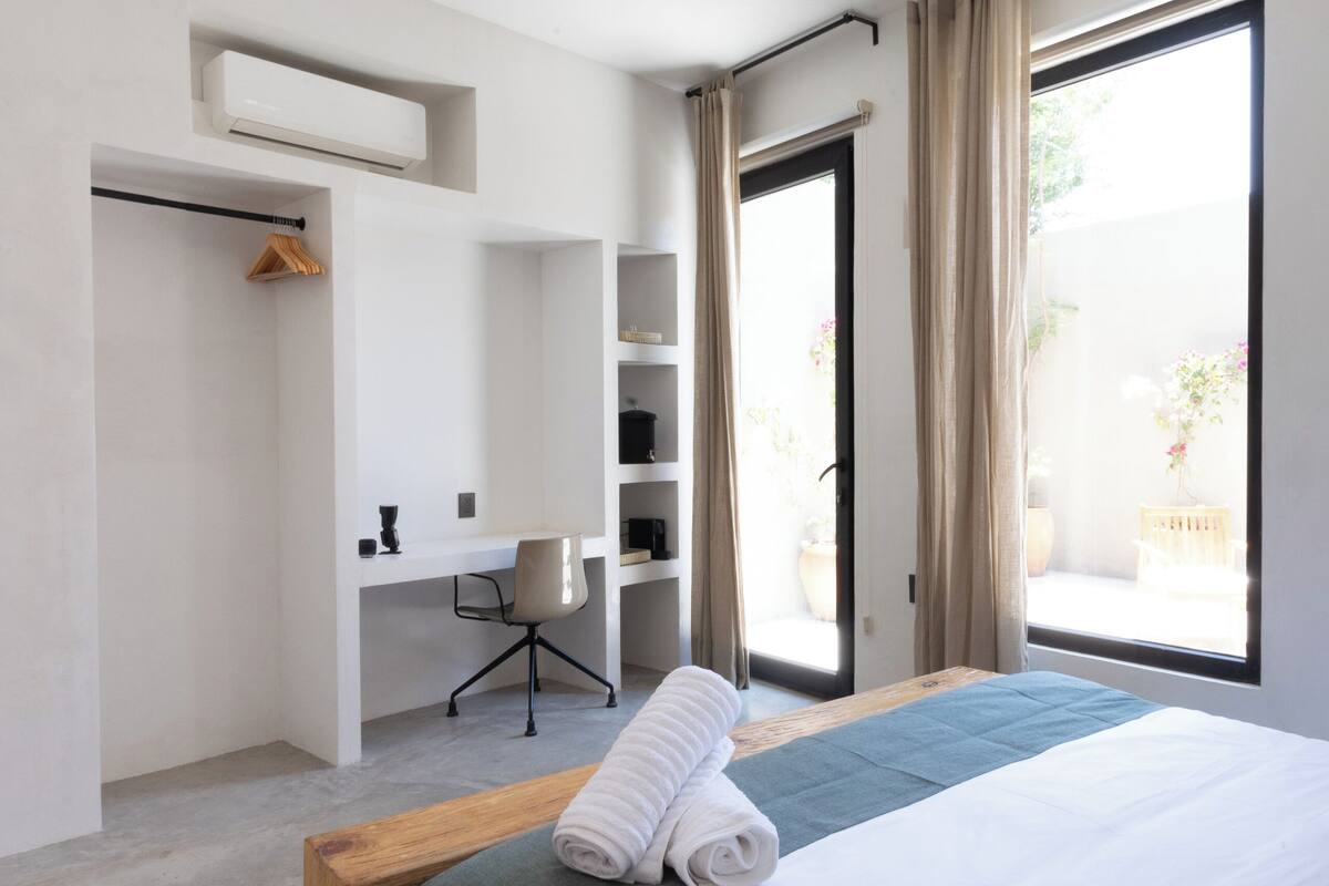 Un dormitorio moderno con una cama grande, un escritorio y un armario.