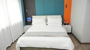 Una habitación de hotel con una cama, dos mesitas de noche y un panel de control en la pared.