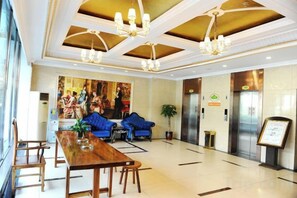 A hotel lobby with a reception desk, seating area, elevators, and a large window. - Mit Holiday Inn (Taiyuan Jianshe South Road Railway Station) (Taiyuan)