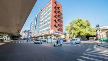 A multi-story building with a red facade and signage in a foreign language.