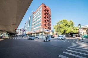 A multi-story building with a red facade and signage in a foreign language. - Mit Holiday Inn (Taiyuan Jianshe South Road Railway Station) (Taiyuan)