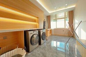 A modern laundry room with a washing machine, dryer, and drying rack. - Mit Holiday Inn (Taiyuan Jianshe South Road Railway Station) (Taiyuan)