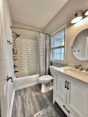 A bathroom with a bathtub, toilet, and sink. - Spacious 8br/5.5ba home in Rehoboth Beach. WiFi, Pool, Pet friendly, Renovated. (Rehoboth Beach)