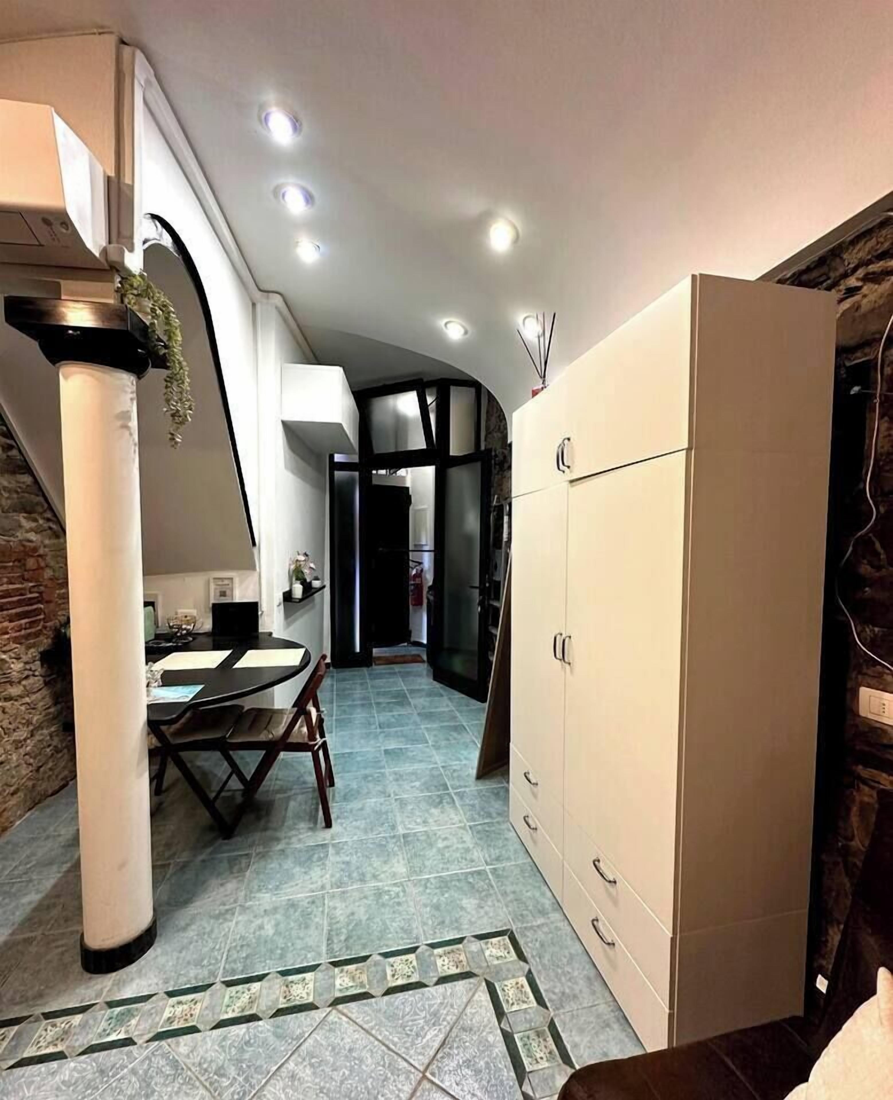 Una cocina moderna con comedor, que incluye un armario grande, una mesa de comedor con sillas y una isla de cocina.