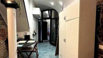 Una cocina moderna con comedor, que incluye un armario grande, una mesa de comedor con sillas y una isla de cocina.