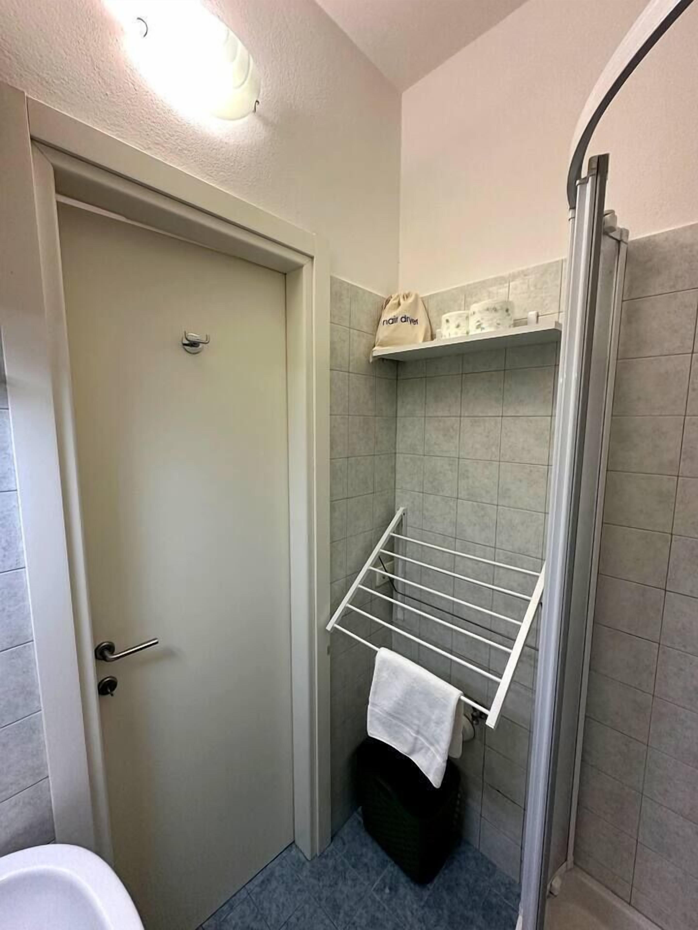 Un bagno con doccia, un portasciugamani e una porta.