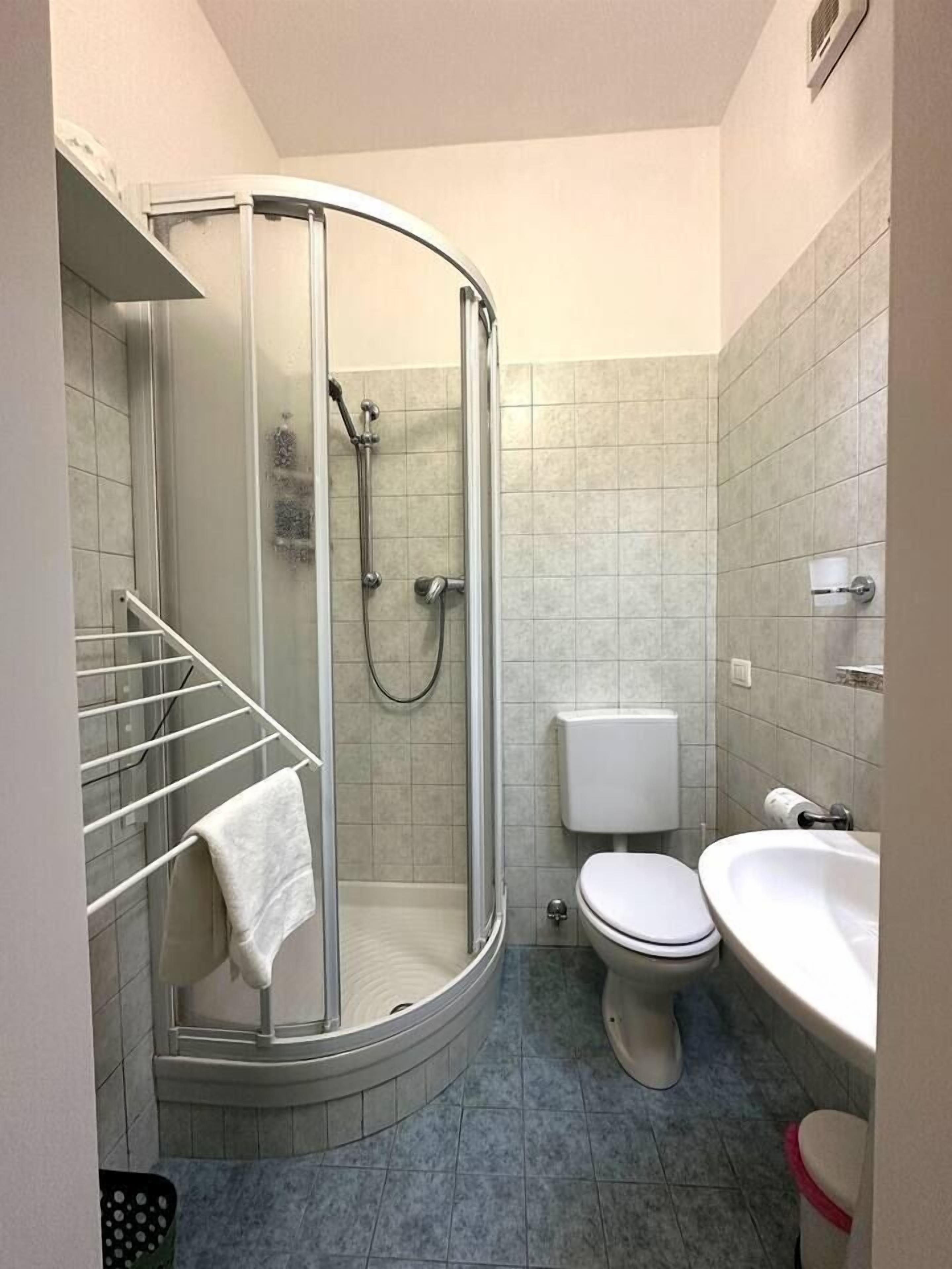 Ein Badezimmer mit Duschkabine, Toilette und Waschbecken.
