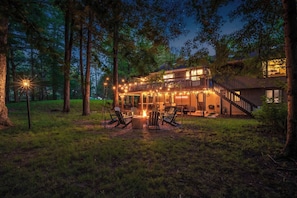 Een huis met twee verdiepingen, een terras, buiten zitplaatsen en een vuurkorf.