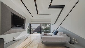 Une chambre moderne avec un lit, une télévision et une vue sur l’extérieur.
