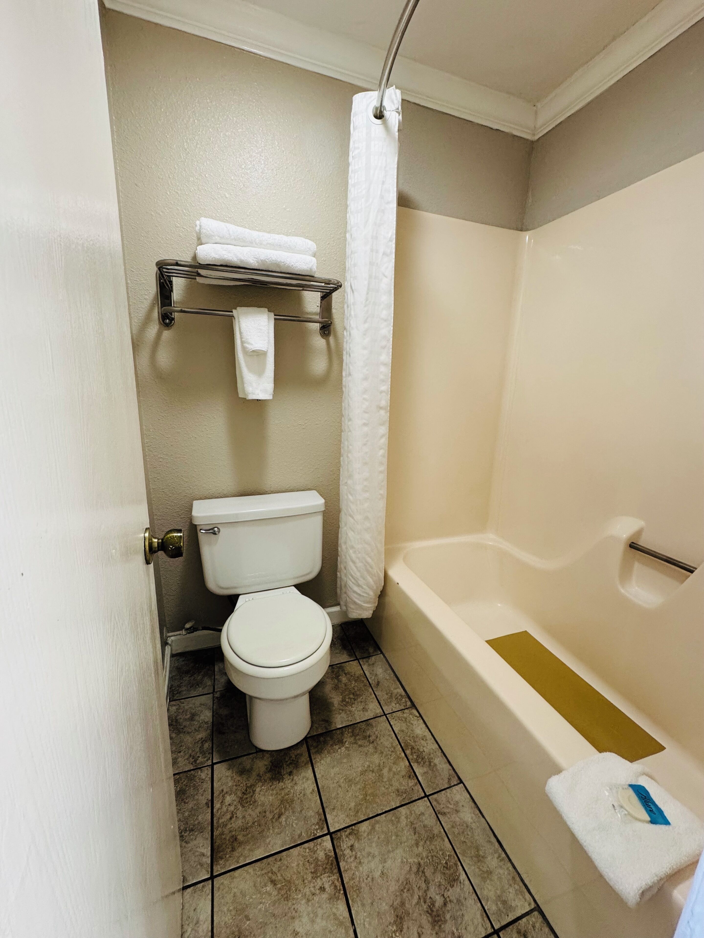 Un baño con inodoro, bañera y cortina de ducha.
