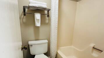 Un baño con inodoro, bañera y cortina de ducha.