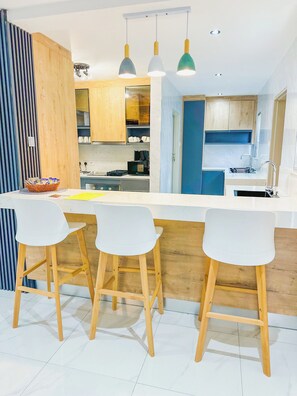 Een koelkast met diepvriezer, een microgolfoven, een oven, een kookplaat