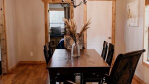 A dining room with a wooden table, chairs, and a chandelier. - A cozy & charming, German-style home in the heart of the Texas Hill Country (Kerrville)