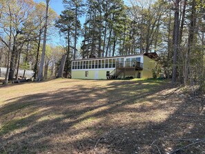 A single-story building with a large windowed front, a deck, and a covered outdoor area.