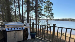 A deck with a grill and a view of a lake. - Lakehouse on the water with amazing view and private dock
WATER STILL AT DOCK-5' (Clarksville)