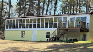 A single-story building with a deck, a door, and a window. - Lakehouse on the water with amazing view and private dock
WATER STILL AT DOCK-5' (Clarksville)