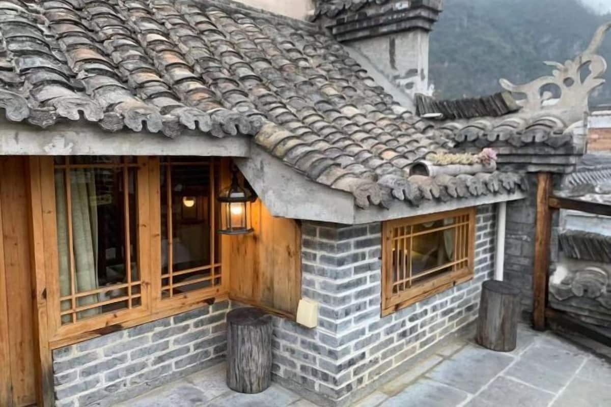 A traditional building with a tiled roof, wooden windows, and stone walls.