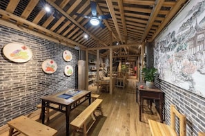 Un interior rústico con vigas de madera a la vista, una pared de ladrillo y un mural.