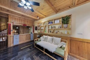 A wooden interior with a sofa, shelves, and a staircase.