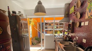 A kitchen with a refrigerator, sink, and a dining area with a mat.