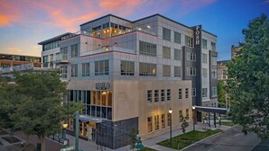 A multi-story hotel with a prominent 'POSH' sign, large windows, and a modern architectural design.