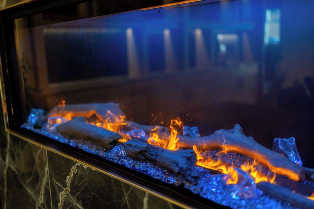 A fireplace with burning logs and embers.