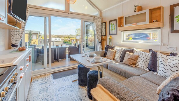 A modern living room with a sofa, a dining table, and a television.