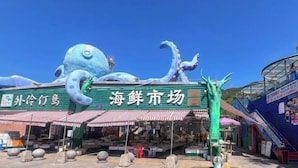 Un marché aux poissons et fruits de mer orné d’une grande sculpture de poulpe.