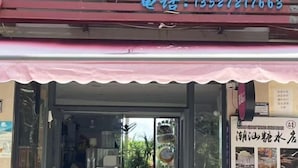 Une devanture de magasin avec une enseigne en caractères chinois et un numéro de téléphone.