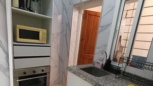 A kitchen with a built-in oven, microwave, and granite countertop. - Modern apartment near beaches and airport (Tetuán)