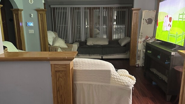 A bedroom with a bed, a TV, and a wooden bench.