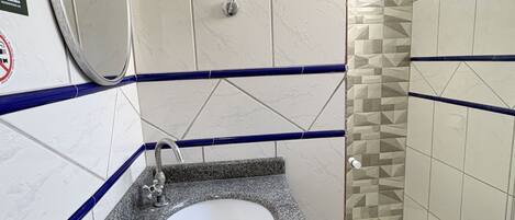 Un baño con lavamanos, espejo e inodoro.