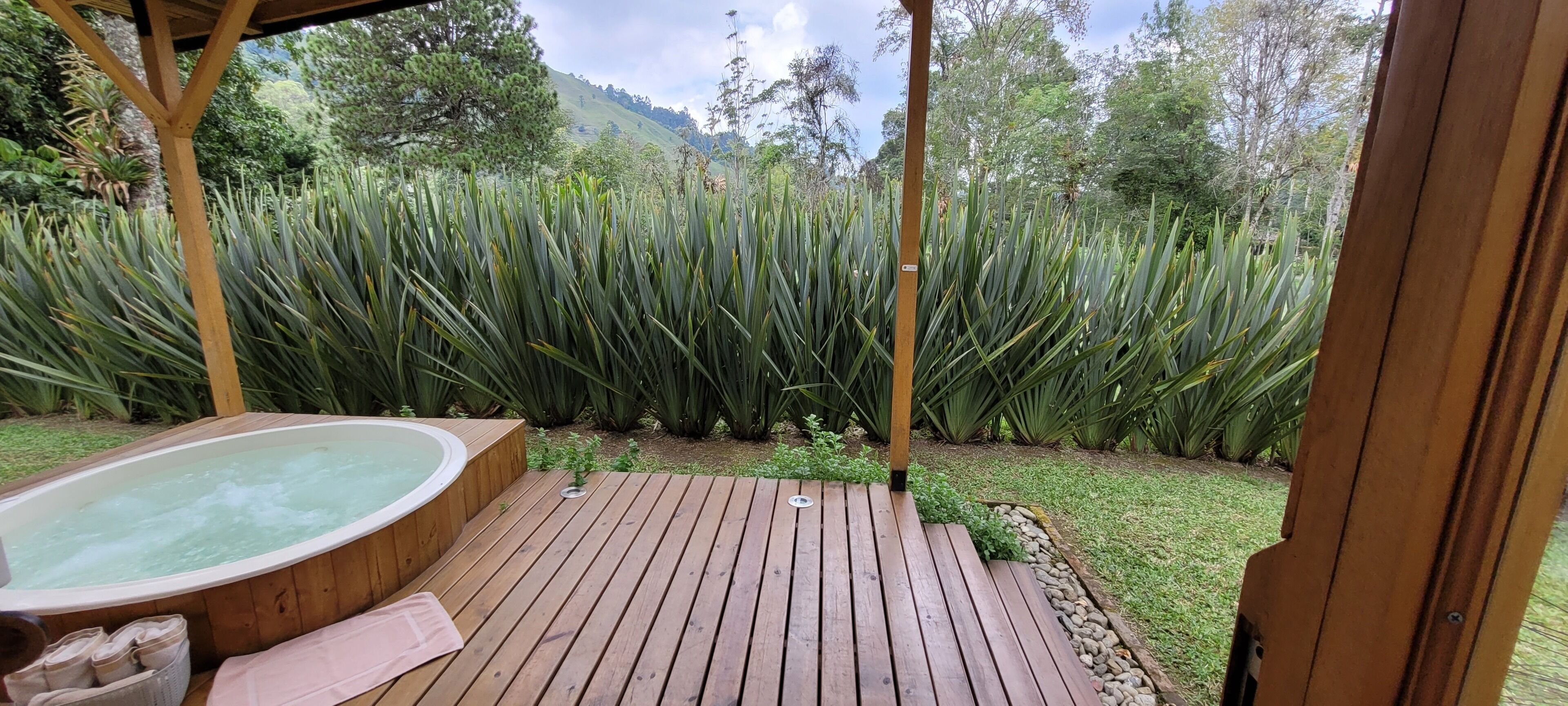 Una terraza de madera con un jacuzzi y una pérgola.
