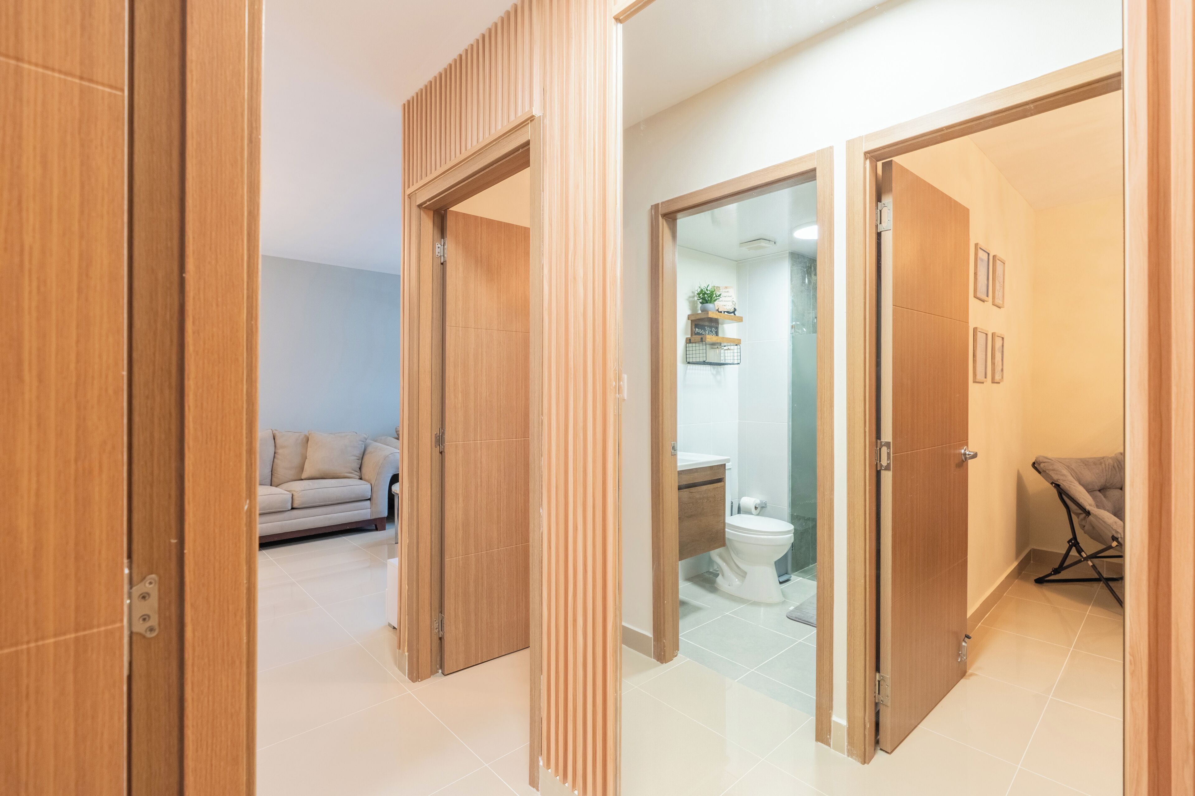 Un interior moderno con puertas de madera que dan a una sala de estar y un baño.