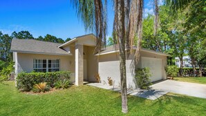 A single-story house with a garage, a well-maintained lawn, and mature trees. - 3-bedroom villa in fantastic Clermont that backs on to a Conservation Area (Clermont)