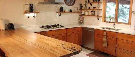 A kitchen with wooden cabinets, a stainless steel sink, and a gas stove.