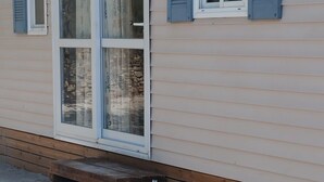 Ein Haus mit einer offenen Holzveranda und einem Steinfundament.