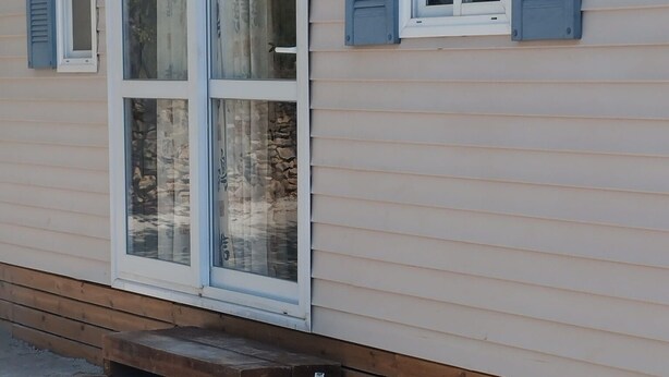 A house with a wooden front porch and a stone foundation. - Zielo Mobil Home (Tirig)