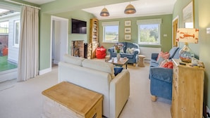 A living room with a fireplace, sofas, a coffee table, and a wooden cabinet.