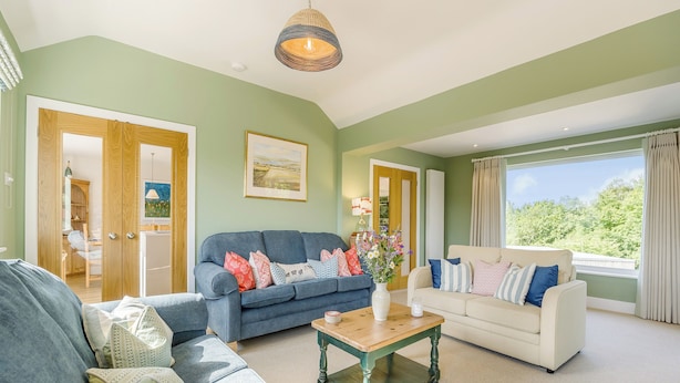 A living room with two sofas, a coffee table, and a painting on the wall.