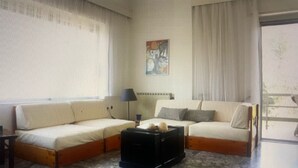 Ein Wohnzimmer mit zwei Sofas, einem Couchtisch, einer Lampe und einem Gemälde an der Wand.