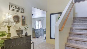 A hallway with a staircase, a sign labeled "ANTIQUE," a lamp, and a framed picture. - Desert Oasis Near Saguaro & Downtown (Tucson)