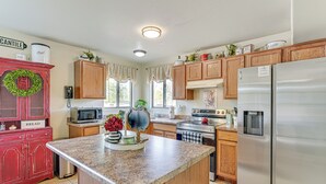 A kitchen with wooden cabinets, a granite countertop, stainless steel appliances, and a microwave. - Desert Oasis Near Saguaro & Downtown (Tucson)