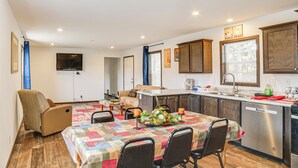A compact kitchen with a dining area, wooden flooring, and a TV mounted on the wall. - Dog-Friendly Miller Hunting Retreat! (Miller)