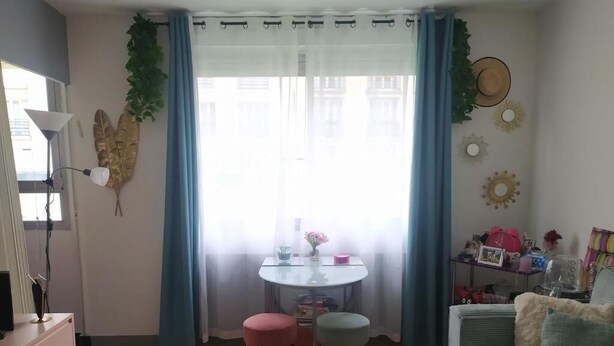 A living room with a sofa, a coffee table, two stools, a TV, and a window with curtains. - Lovely studio close to Champs Elysées (Paris)