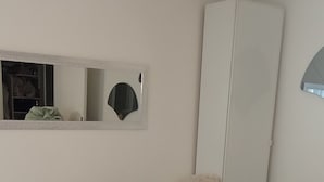 A bedroom with a bed, a wardrobe, a mirror, and a window. - Lovely studio close to Champs Elysées (Paris)
