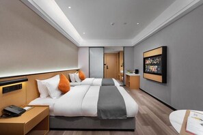 Habitación de hotel moderna con una cama grande, un escritorio, un televisor de pantalla plana y vistas al pasillo.