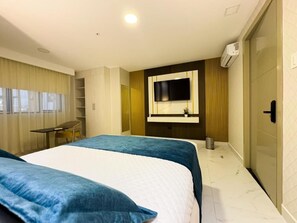 A modern hotel room with two beds, a large mirror, a TV, and a wardrobe. - Hotel DSH (Manta)