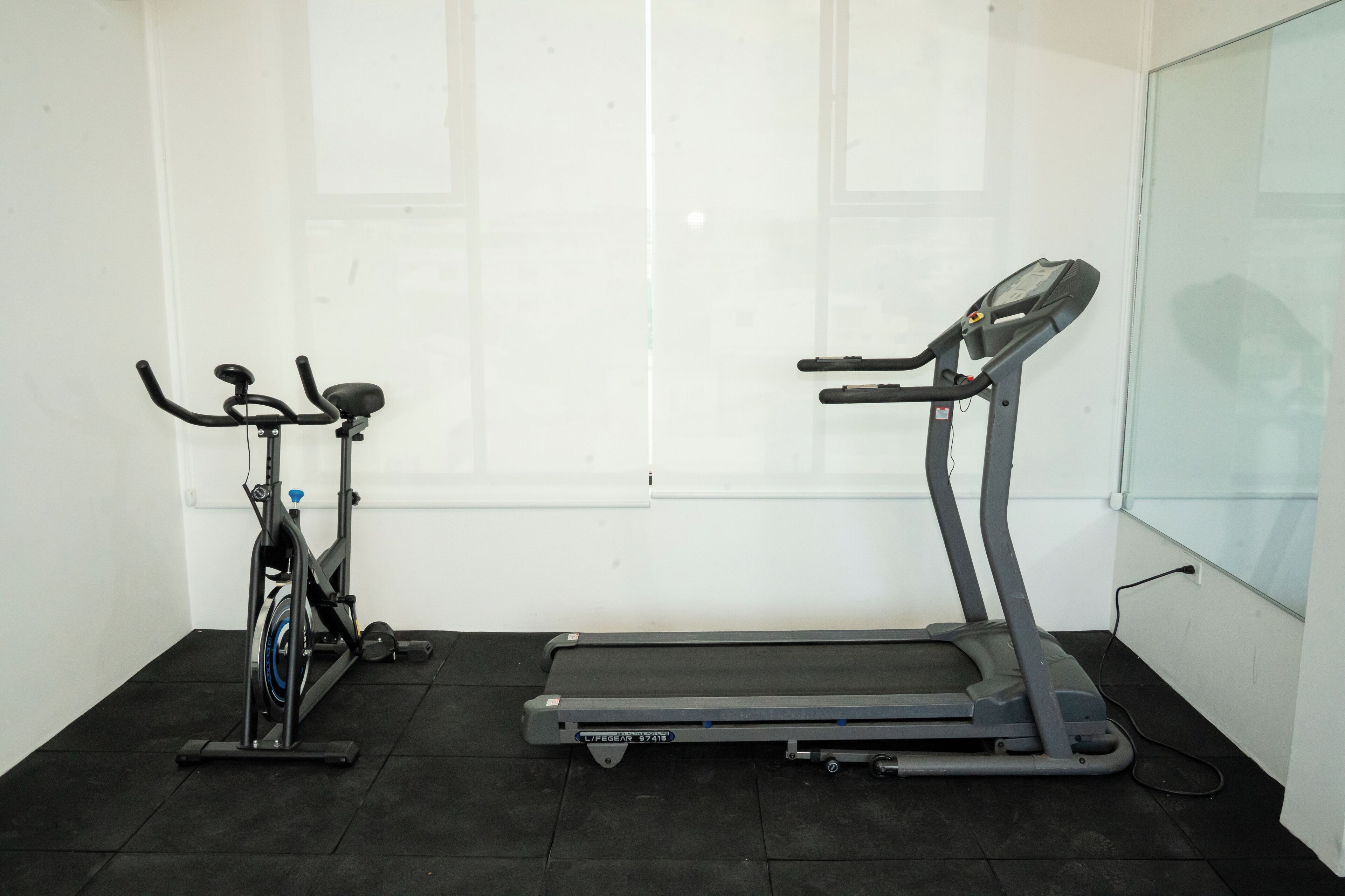 Quarto com bicicleta ergométrica e esteira.