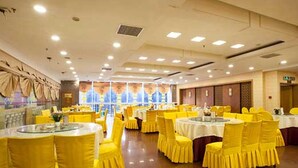 A banquet hall with round tables, yellow chairs, and a polished floor. - Vienna International Hotel Changsha Gaoqiao Branch (Changsha)